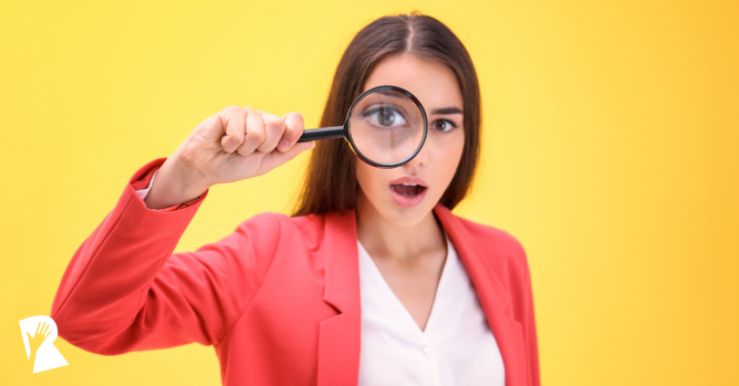 Woman looking into a magnifying glass