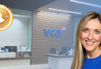Smiling woman in blue at a VCA reception desk with an award badge overlay in the corner.